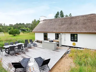 a white house with a deck with tables and chairs at 7 person holiday home in Fjerritslev-By Traum in Fjerritslev
