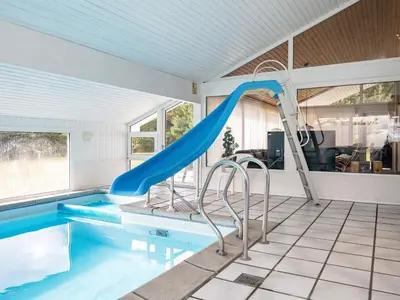 a swimming pool with a slide in a house at Luxury Pool House Retreat - By Traum Ferienwohnungen in Saltum