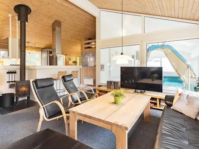 a living room with a table and a tv at Luxury Pool House Retreat - By Traum Ferienwohnungen in Saltum
