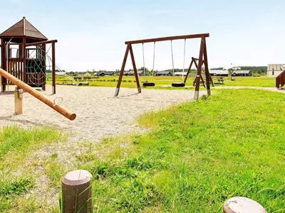 an empty playground with a swing set in a field at 6 person holiday home in Brovst-By Traum in Brovst