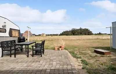a patio with a table and chairs next to a rv at Stunning Home In Harboøre With Wifi in Harboør