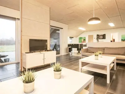 a living room with a couch and a tv and tables at Holiday home for 24 guests, Brovst in Brovst