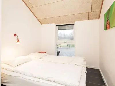 a bedroom with a white bed and a window at Holiday home for 24 guests, Brovst in Brovst