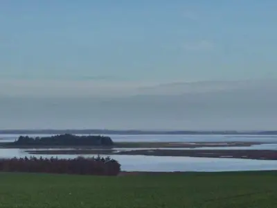 a view of a large body of water with a field at Scenic Retreat in Boddum - By Traum Ferienwohnungen in Boddum