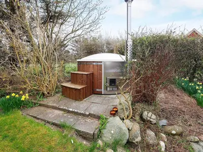 a outhouse sitting in the middle of a garden at 10 person holiday home in Karby-By Traum in Karby