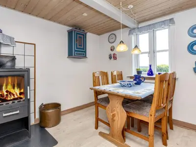 a dining room with a table and a fireplace at 6 person holiday home in Thisted-By Traum in Thisted