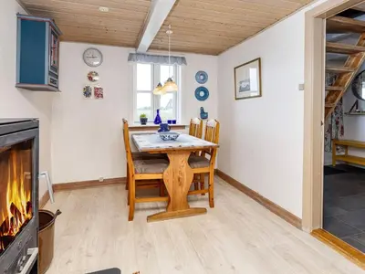 a dining room with a table and chairs and a fireplace at 6 person holiday home in Thisted-By Traum in Thisted