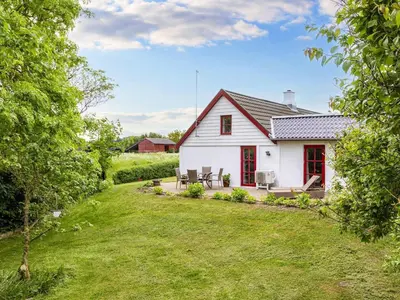 a white house with red windows and a yard at 6 person holiday home in Thisted-By Traum in Thisted