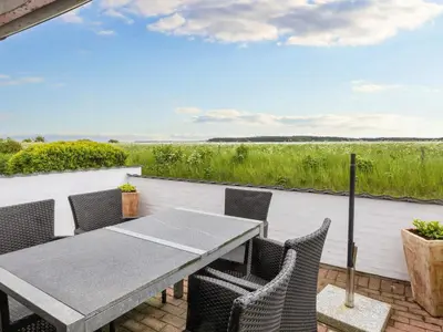 a table and chairs on a patio with a view of a field at 6 person holiday home in Thisted-By Traum in Thisted