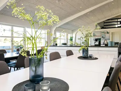 a kitchen with a table with a vase of flowers on it at 22 person holiday home in Løkken-By Traum in Løkken