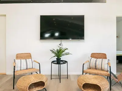 two chairs and a table with a tv on a wall at 22 person holiday home in Løkken-By Traum in Løkken