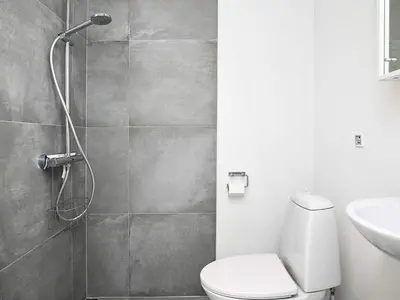 a bathroom with a shower with a toilet and a sink at 22 person holiday home in Løkken-By Traum in Løkken