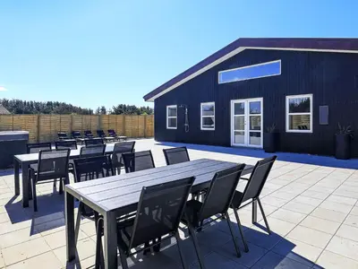 a group of tables and chairs on a patio at 22 person holiday home in Løkken-By Traum in Løkken