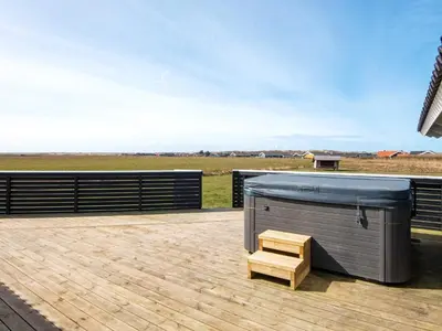 a hot tub and a wooden bench on a deck at 10 person holiday home in Harboøre in Harboør
