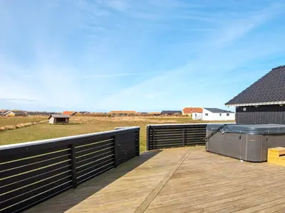 a wooden deck with a view of a field at 10 person holiday home in Harboøre in Harboør