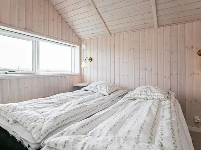 a white bed in a room with a window at 10 person holiday home in Harboøre in Harboør
