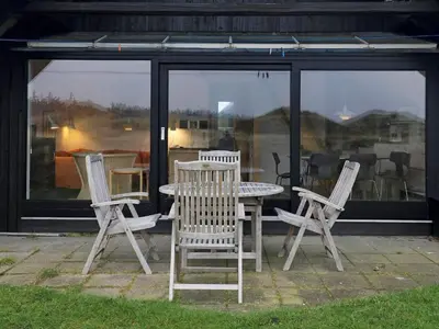 a table and four chairs sitting in front of a house at 6 person holiday home in Pandrup-By Traum in Pandrup