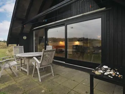 a patio with a table and chairs next to a building at 6 person holiday home in Pandrup-By Traum in Pandrup