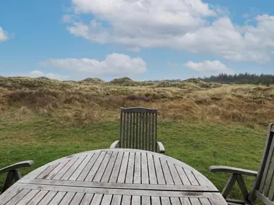 a wooden table with two chairs and a field at 6 person holiday home in Pandrup-By Traum in Pandrup