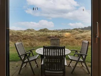 a table and chairs with a view of a field at 6 person holiday home in Pandrup-By Traum in Pandrup