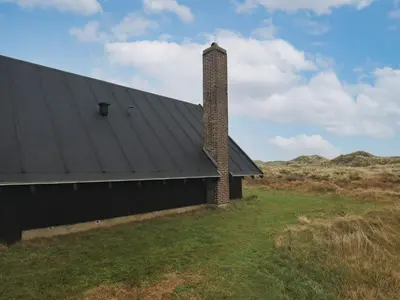 a building with a brick chimney on the side of it at 6 person holiday home in Pandrup-By Traum in Pandrup