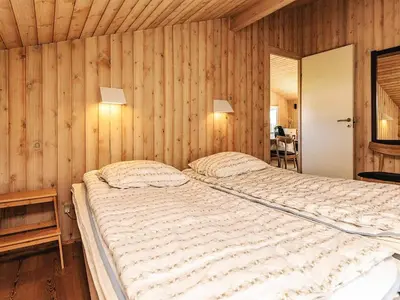 a bedroom with a large bed with wooden walls at Luxury Retreat in Klitmoller - By Traum Ferienwohnungen in Thisted