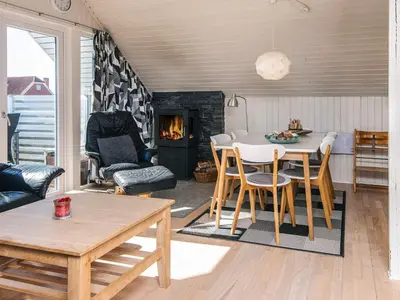 a living room with a table and a fireplace at 6 person holiday home in Harboøre-By Traum in Harboør