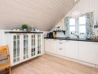 a kitchen with white cabinets and a wooden floor at 6 person holiday home in Harboøre-By Traum in Harboør