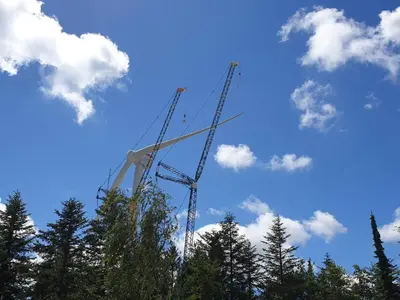 a construction crane against a blue sky with trees at 7 person holiday home in Frøstrup in Frøstrup