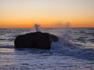 a rock in the ocean with water splashing around it at 7 person holiday home in Frøstrup in Frøstrup