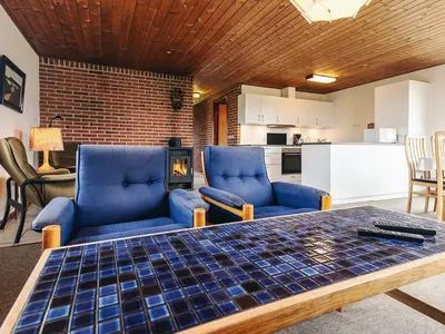 a living room with two blue chairs and a table at 7 person holiday home in Frøstrup in Frøstrup