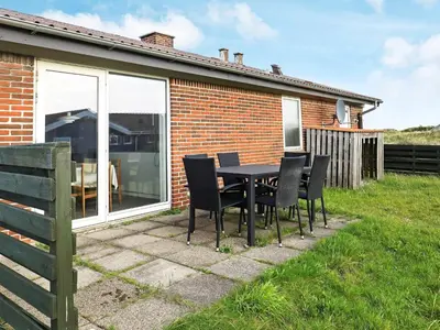 a table and chairs in front of a house at 7 person holiday home in Frøstrup in Frøstrup
