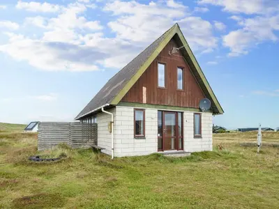 a small house sitting on top of a field at 5 person holiday home in Harboøre-By Traum in Harboør