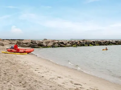 a man is in a boat on the beach at 8 person holiday home in Thyborøn-By Traum in Thyborøn