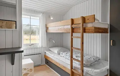 a bunk bed in a small room with a window at Cozy Home In Vestervig With Sauna in Vestervig