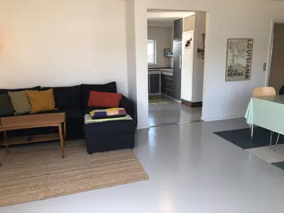 a living room with a black couch and a kitchen at 6 person holiday home in Thyborøn-By Traum in Thyborøn