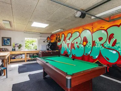 a pool table in a room with graffiti on the wall at 6 person holiday home in Thyborøn-By Traum in Thyborøn