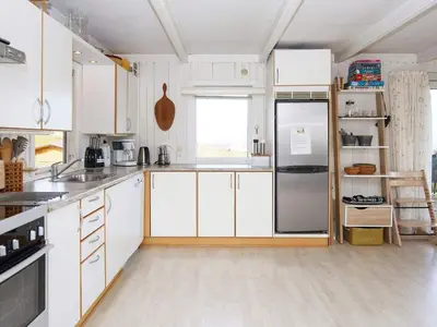 a kitchen with white cabinets and a stainless steel refrigerator at 8 person holiday home in Lemvig-By Traum in Lemvig