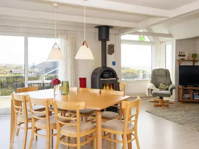 a dining room with a table and a wood stove at 8 person holiday home in Lemvig-By Traum in Lemvig