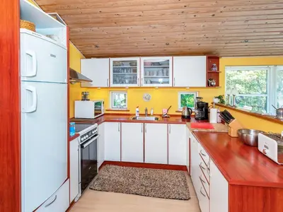 a kitchen with white appliances and wooden ceilings at 6 person holiday home in Løgstør-By Traum in Løgstør