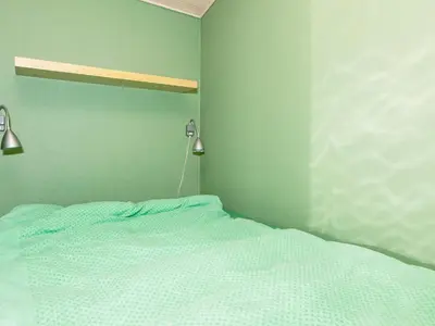 a bed in a room with green walls at 6 person holiday home in Løgstør-By Traum in Løgstør