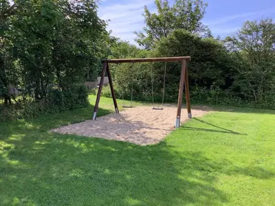 a swing set in a field of grass at 7 person holiday home in Vestervig-By Traum in Vestervig