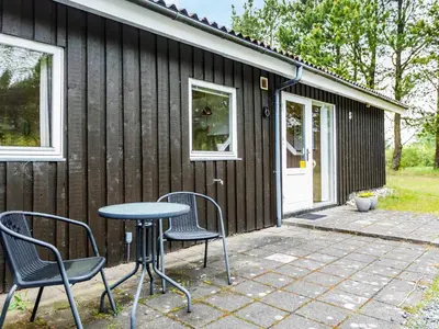 a patio with chairs and a table in front of a house at 6 person holiday home in Fjerritslev in Fjerritslev