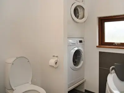 a bathroom with a toilet and a washing machine at 8 person holiday home in Ulfborg-By Traum in Ulfborg