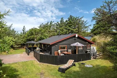 a black cabin with a fence and a patio at BL1112-Saltum-Graabakken-26 in Saltum