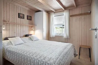 a bedroom with a bed with a white comforter and a window at BL1113-Saltum-Revlingevej-26 in Saltum