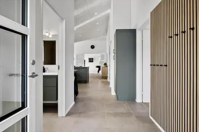 a hallway with white walls and a kitchen with blue cabinets at BL1118-Saltum-Vesterhavs-Sletten-37 in Saltum