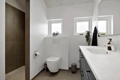 a white bathroom with a toilet and a sink at BL1118-Saltum-Vesterhavs-Sletten-37 in Saltum