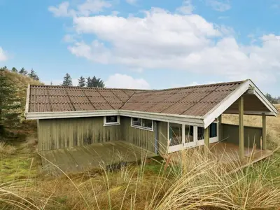 a small house with a tin roof in a field at Spacious Retreat with Views - By Traum Ferienwohnungen in Blokhus