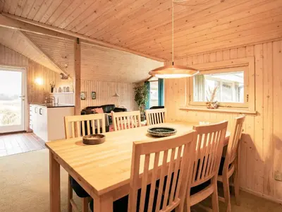 a kitchen and dining room with a wooden table and chairs at Spacious Retreat with Views - By Traum Ferienwohnungen in Blokhus